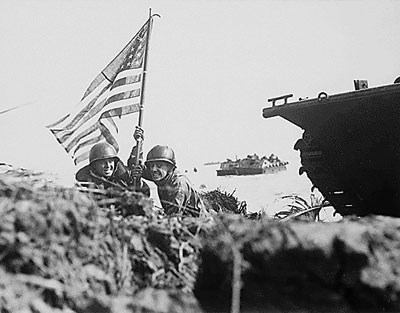 Two U.S. Marines plant the American flag on Guam eight minutes after U.S. Marine and Army assault troops landed