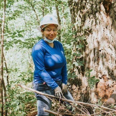 Angela smiling while holding tree branches in her SCA uniform