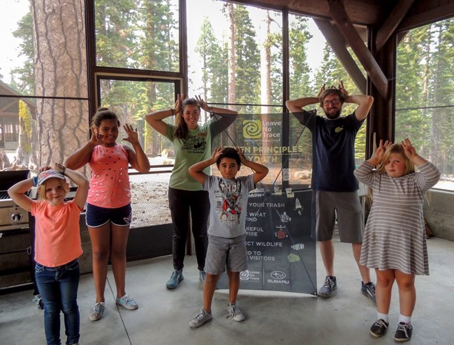 A group of Girl Scouts pose for a photo with Leave No Trace trainers Donielle and Aaron inside a picnic pavilion at the Volcano Adventure Camp A group of Girl Scouts pose for a photo with Leave No Trace trainers Donielle and Aaron inside a picnic pavilion at the Volcano Adventure Camp