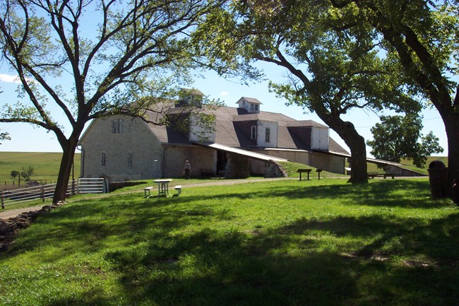 summer view of massive three story limestone barn