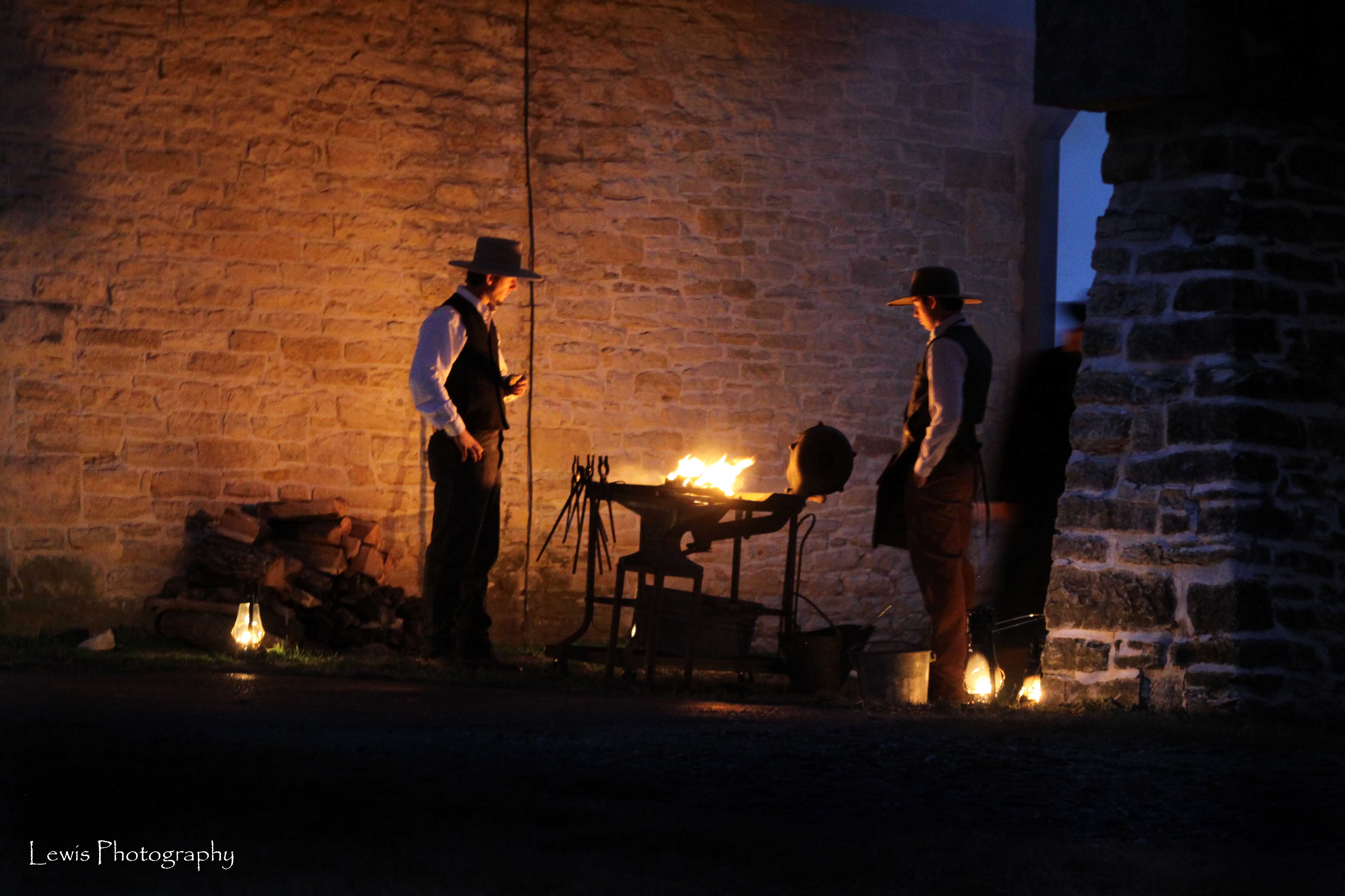 Candlelight Tour cowboys working hot metal in the forge among lantern light