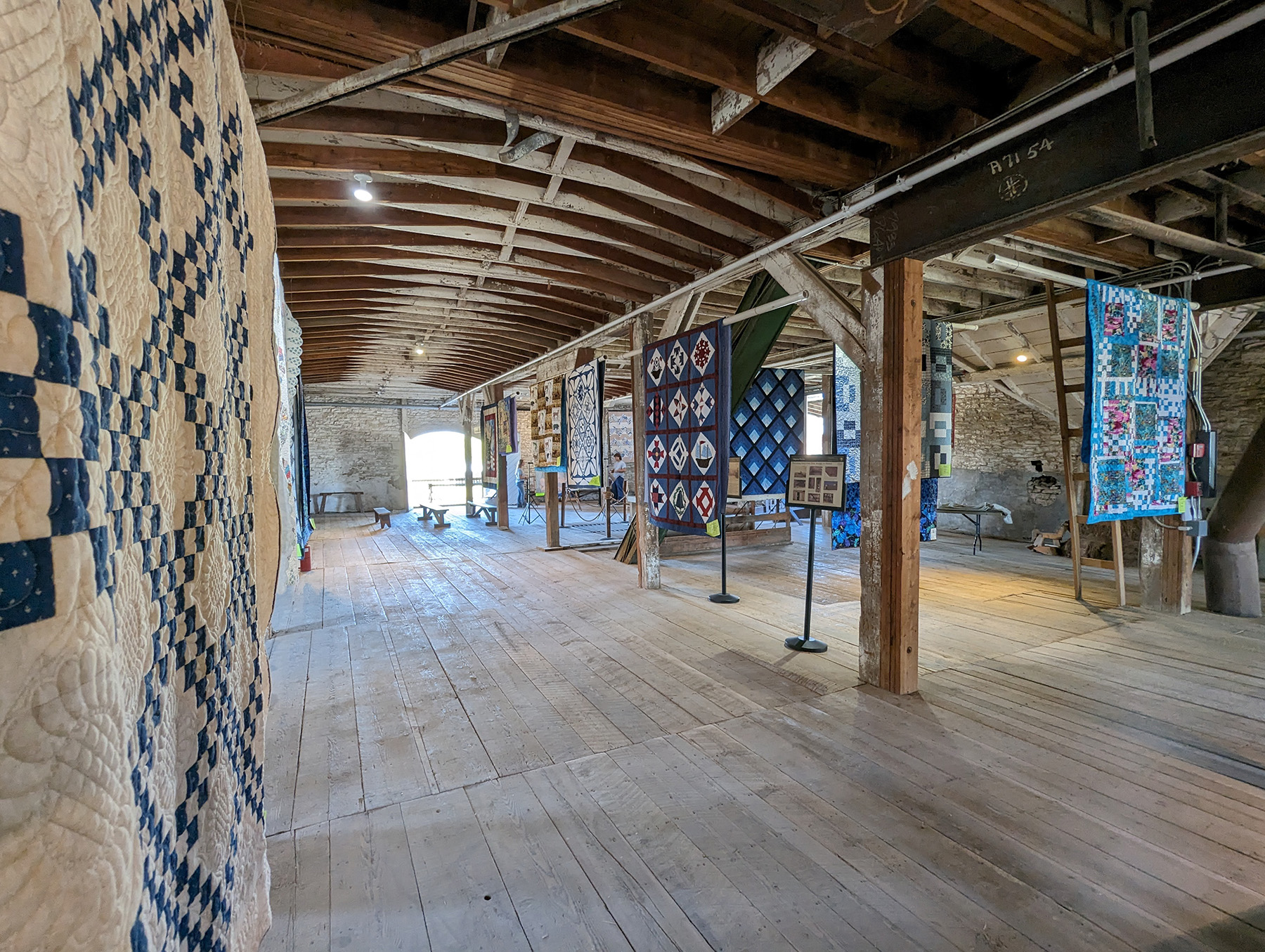 quilts on display in a historic barn photo of quilts in a historic barn
