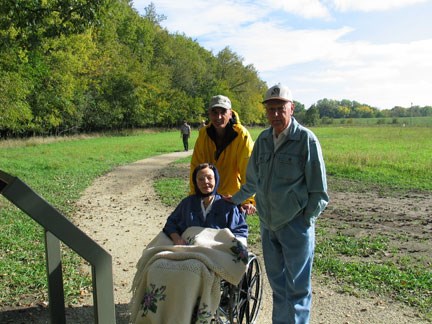 Three visitors enjoying the waysides along the wheelchair friendly Bottomland Trail. This family gave a donation in honor of their late son, Roger Cloud, to assist with the initial development of the trail.