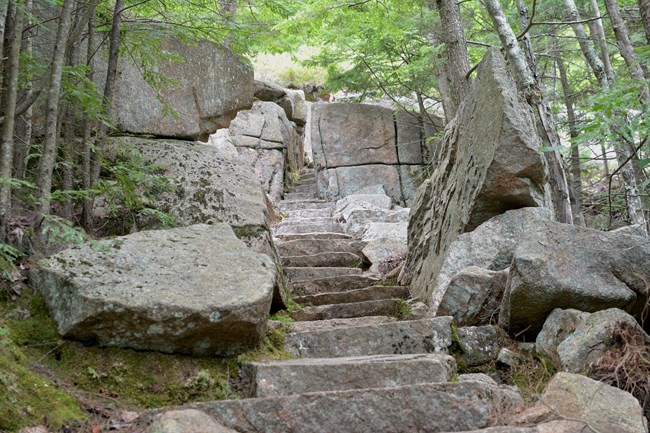 Steps and an opening cut out of granite on a hiking trail