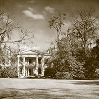 Melrose two-story house featuring front columns and a widow;s walk on top