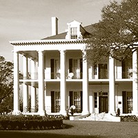 large two-story house with columns and first and second story porches across the front
