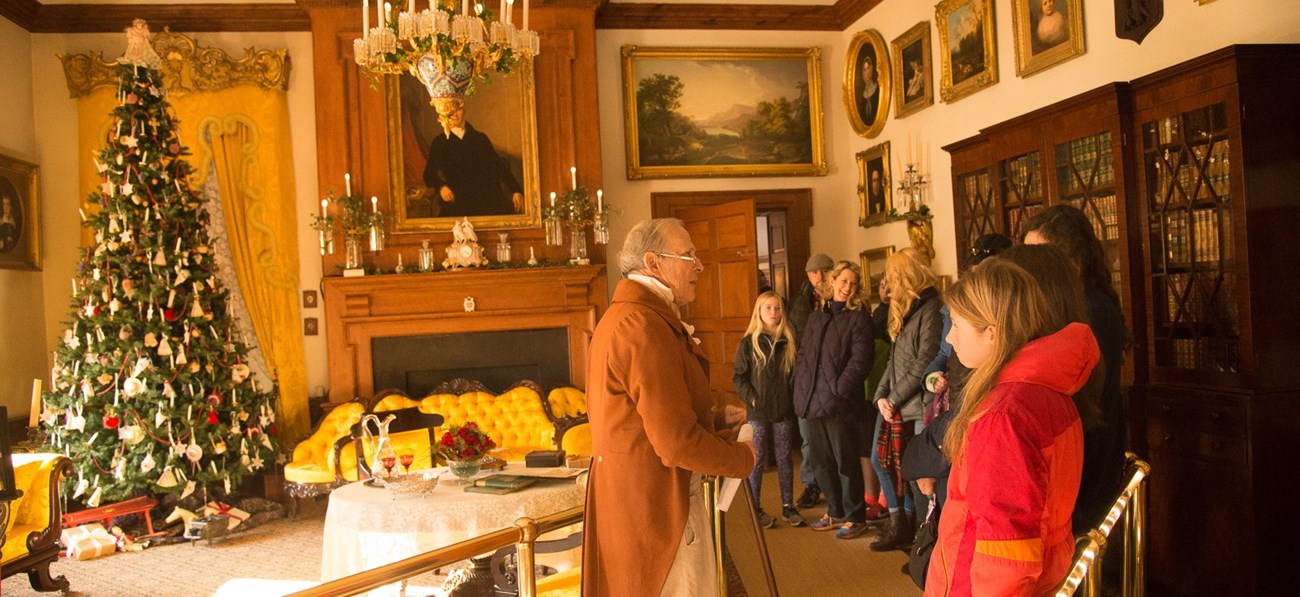 National Park Service volunteer greets visitors in the Music Room during Holidays at Hampton. National Park Service volunteer greets visitors in the Music Room during Holidays at Hampton.
