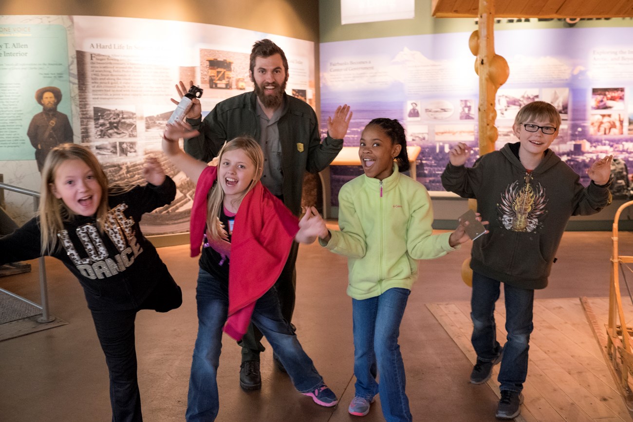 Ranger and kids at FAPLIC A ranger and four children pose for a picture in the visitor center