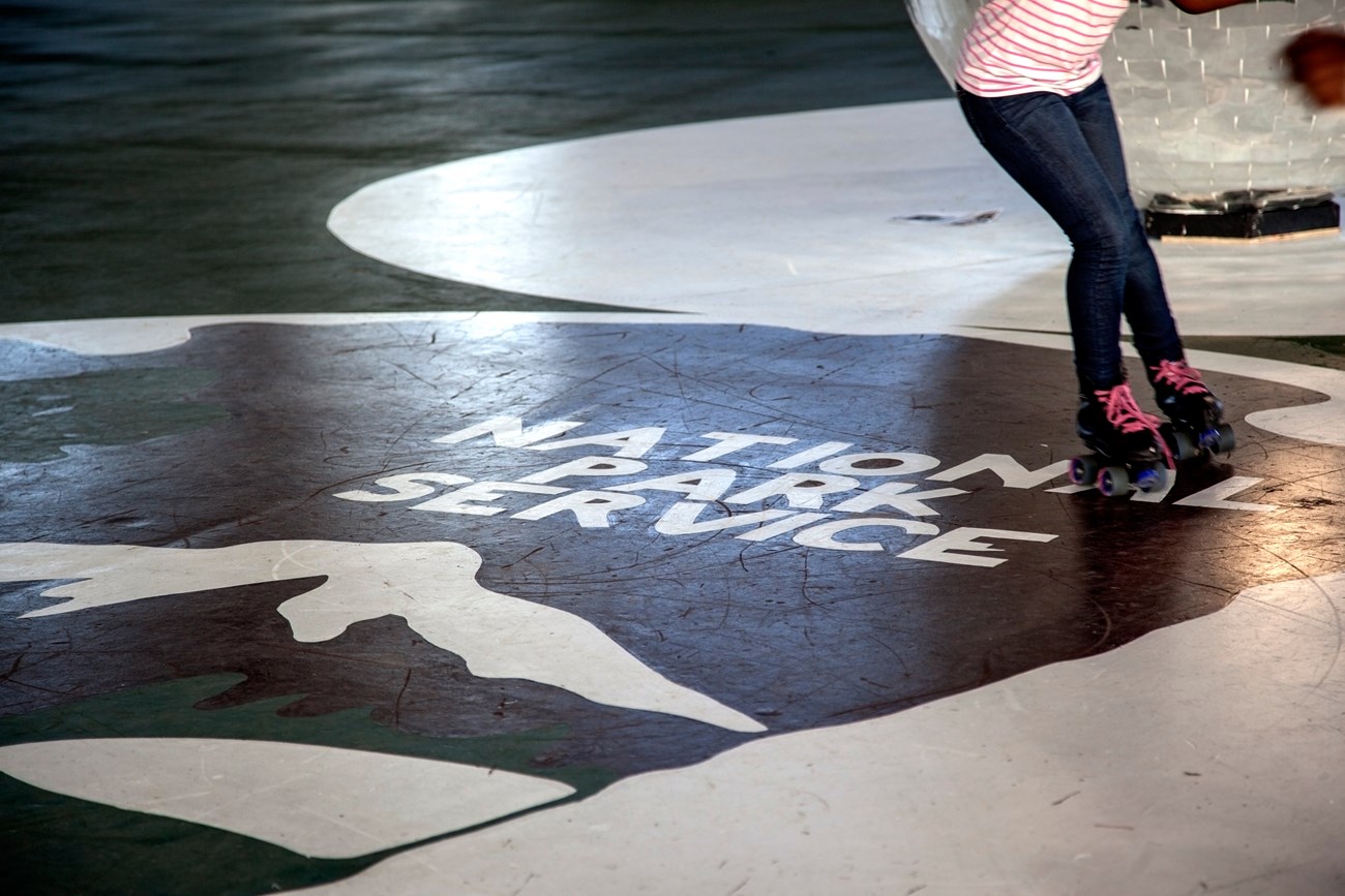 A girl skates over a National Park Service logo