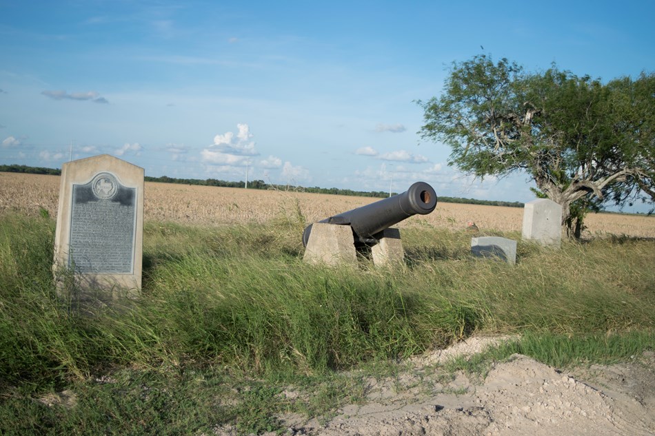 Stone historical marker and replica cannon by the roadside. Stone historical marker and replica cannon by the roadside.