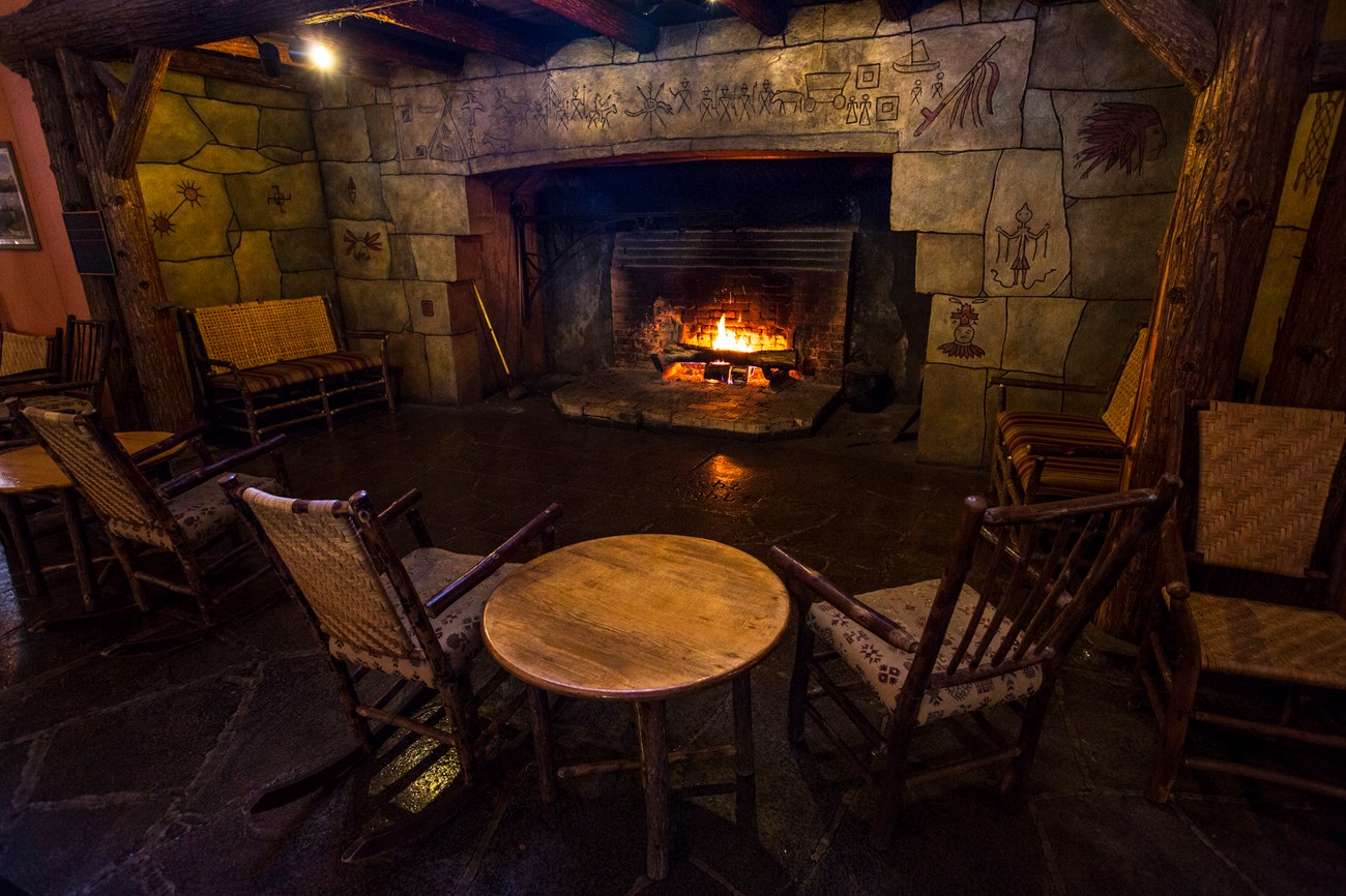 Chairs before cavernous stone fireplace