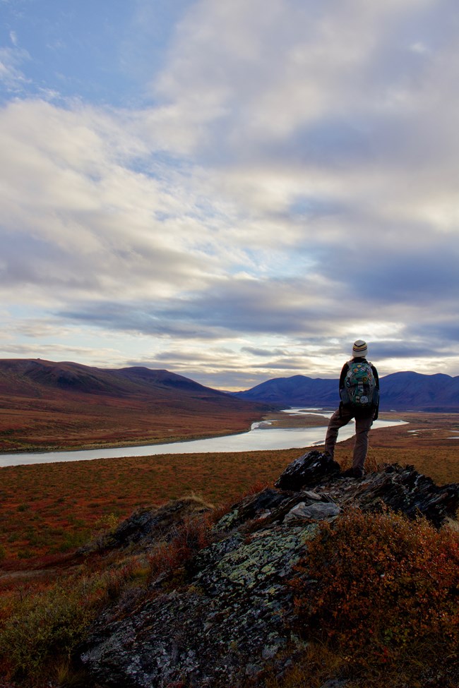 A visitor on the top of a mountain looking out towards the Noatak River