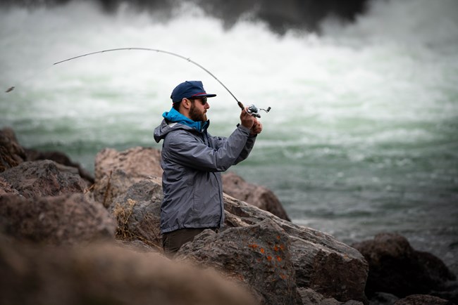 Angler casting line at Jackson Lake Dam