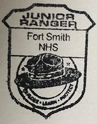 Shape: Ranger Badge with ranger hat in center Text reads Junior Ranger Fort Smith NHS Explore Learn Protect
