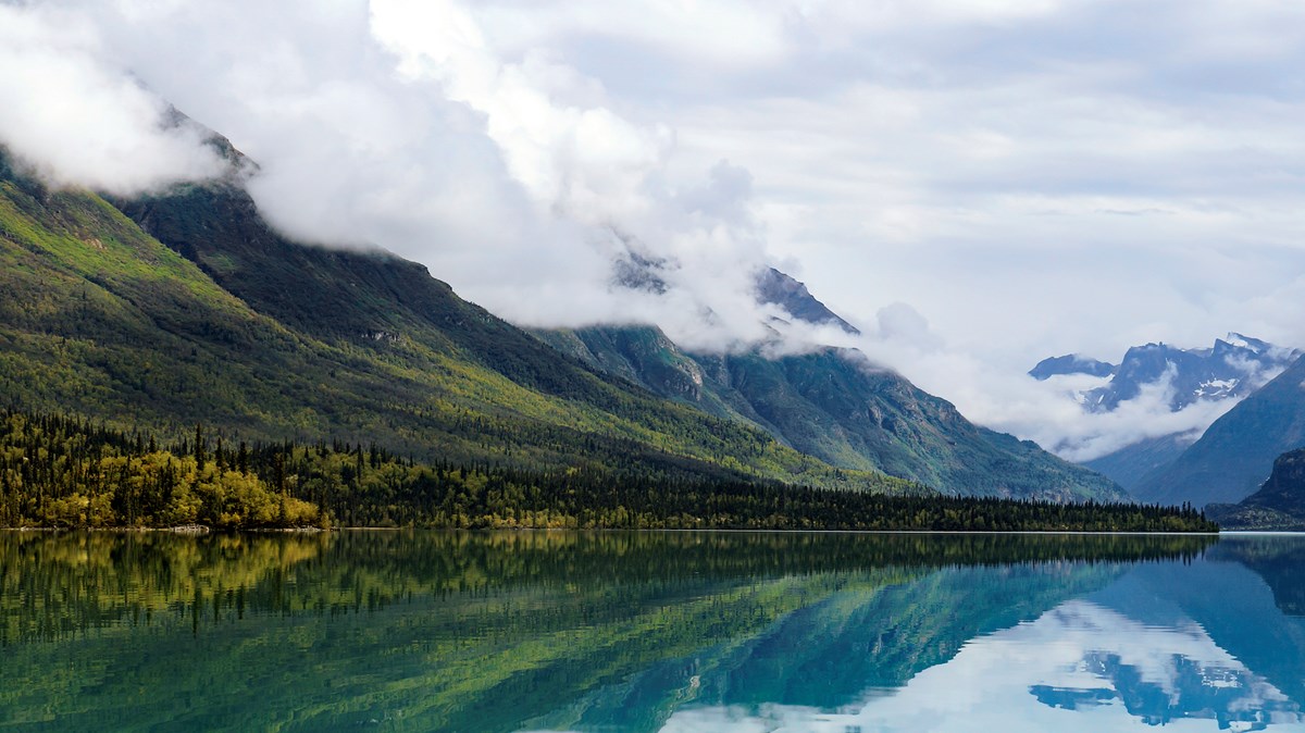 Kontrashibuna Lake Mountains and trees reflect in blue water