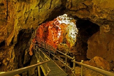 Metal walkway and stairs going through a cave room.