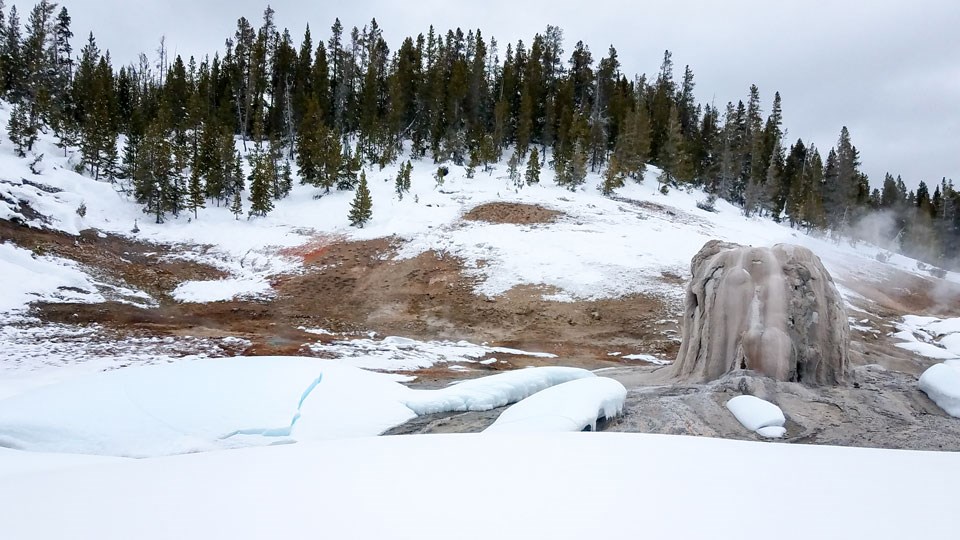Lone Star Geyser in the winter Snow surrounds the tan cone of Lone Star Geyser.