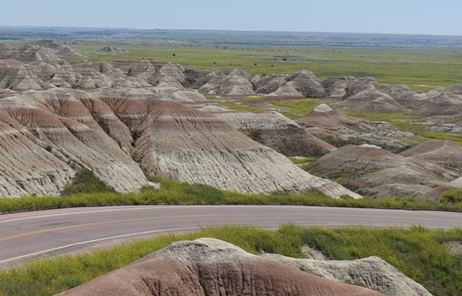 View of the Badlands Loop Road winding through red and white striped Badlands formations.