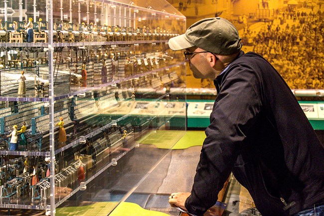 man stands looking at mill model in Boott Cotton Mills Museum