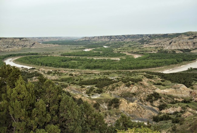 Scenic view of a river valley bottom and Badlands.