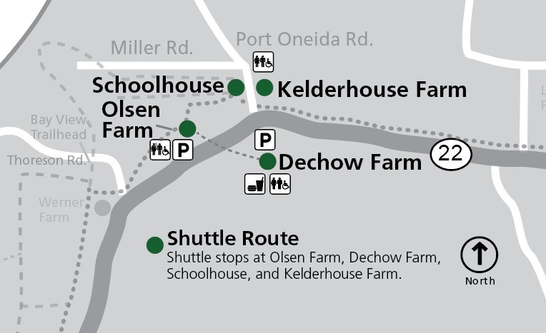 POF map 2025 This map shows the Port Oneida area within Sleeping Bear Dunes National Lakeshore, focusing on shuttle stops and historic farm sites along M-22. The map is oriented with north at the top, as indicated by a compass rose. The primary road, M-22, runs horizo