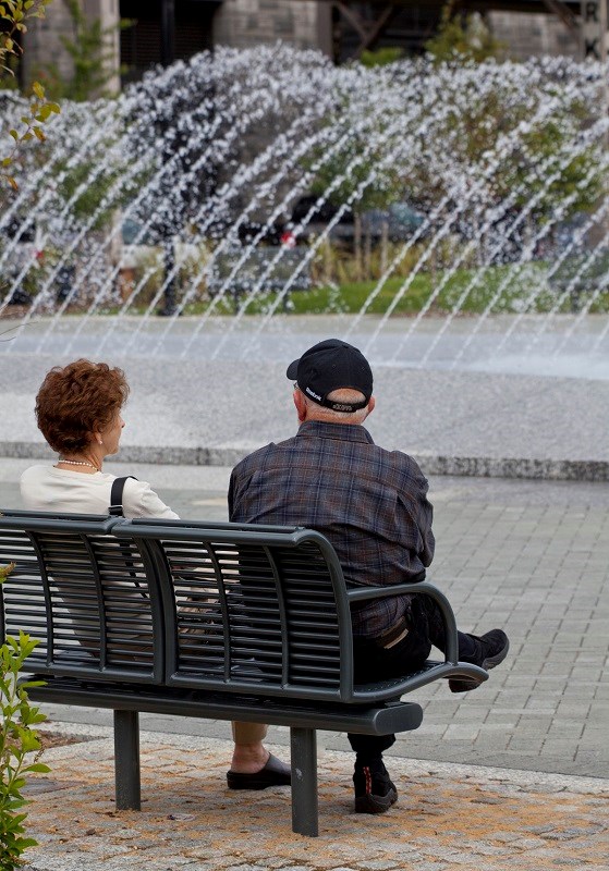 Two visitors sit by the fountains at Georgetown Waterfront Park. Two visitors sit by the fountains at Georgetown Waterfront Park.