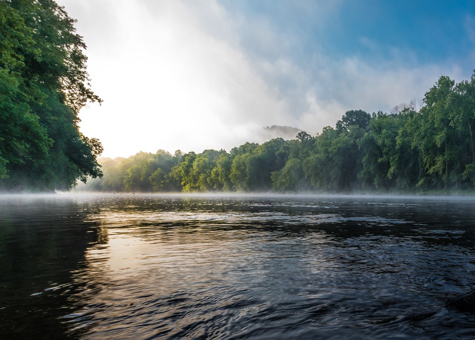 Sunlight streams over the early morning river. Sunlight streams over the early morning river.