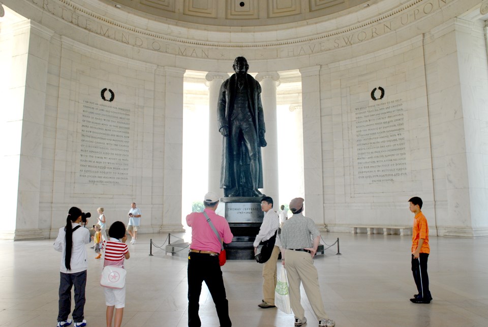 A group of adults and children take photos of a bronze statue of Thomas Jefferson A group of adults and children take photos of a bronze statue of Thomas Jefferson
