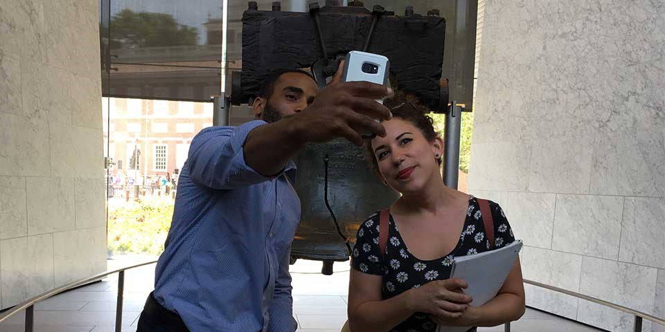Color photo of a man and woman taking a "selfie" photo in front of the Liberty Bell. Color photo of a man and woman taking a "selfie" photo in front of the Liberty Bell.