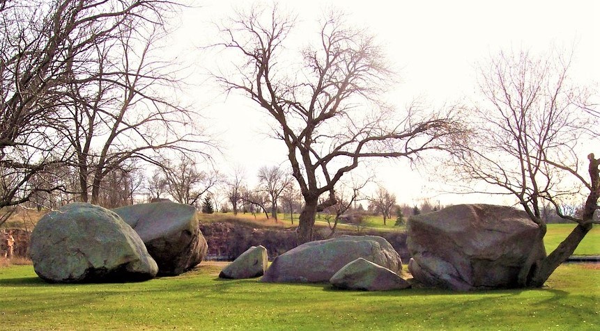 Three Maidens Large boulders among trees and grass