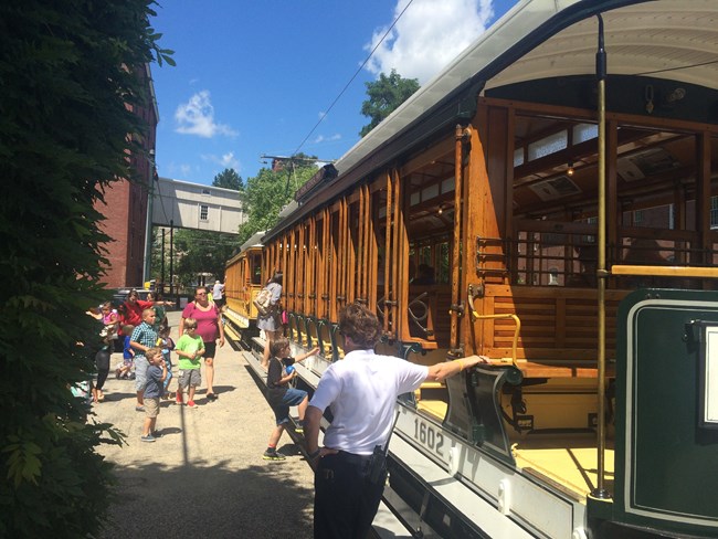 Visitors climb aboard one of Lowell National Historical Park's trolleys.