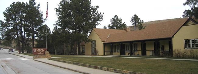 wind cave visitor center, a yellow building with a sign reading Wind Cave National Park Visitor Center and Headquarters