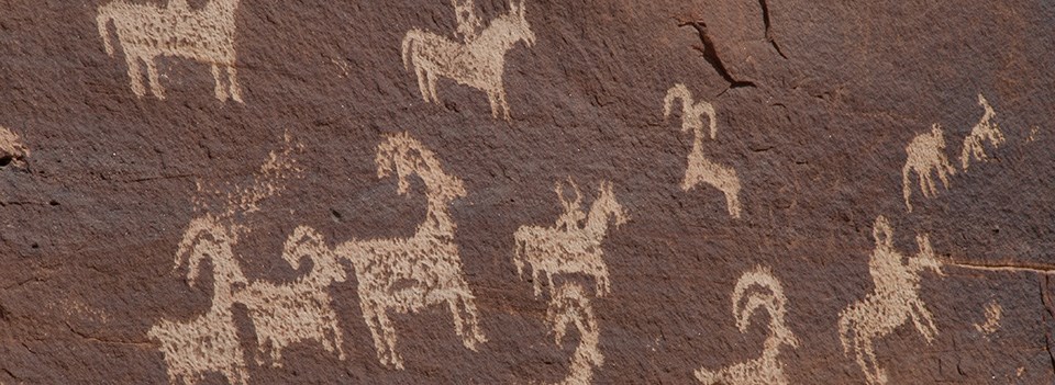WolfeRanch-0281 figures of sheep and riders on horseback carved on a rock wall