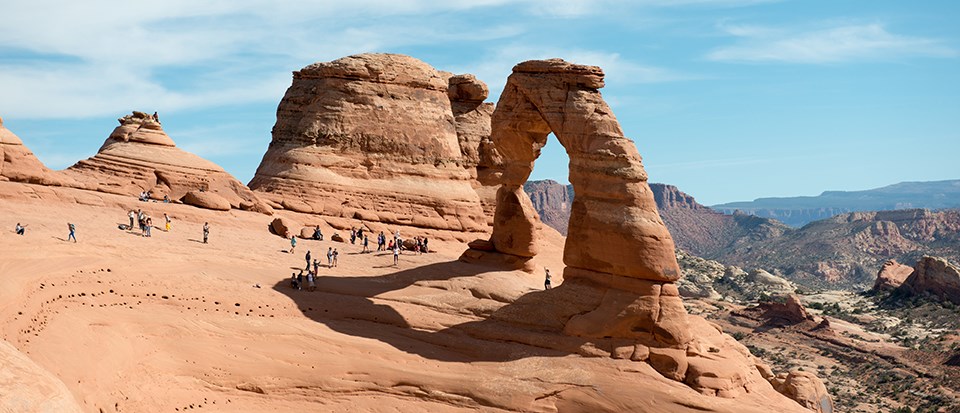 DelicateArch a free-standing stone arch with people standing at its base