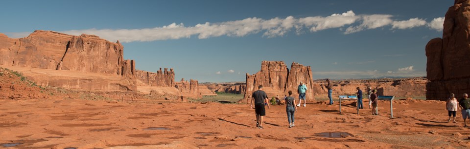_DSC7448 people stand on rocky ground with pinnacles and spires in the distance