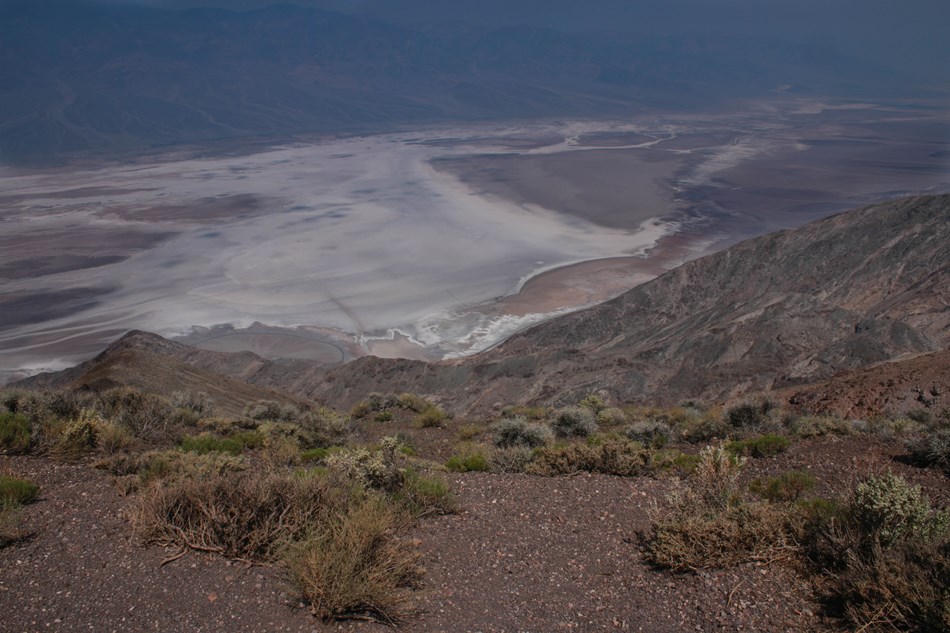 A view of a vast desert valley from a rocky desert mountain top. A view of a vast desert valley from a rocky desert mountain top.