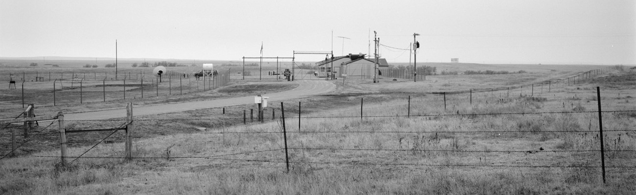 Looking southwest to Delta-1, 1992 A large ranch-style structure located inside a fenced enclosure