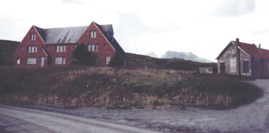 two large brick buildings in a field