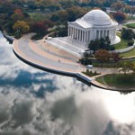 image of jefferson memorial. memorial on right, clouds reflected in water on left
