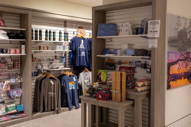 Displays of t-shirts, mugs, books, and other souvenirs for sale.