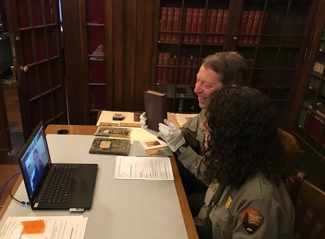 image of two rangers sitting at a desk giving a distance learning program to students over the internet