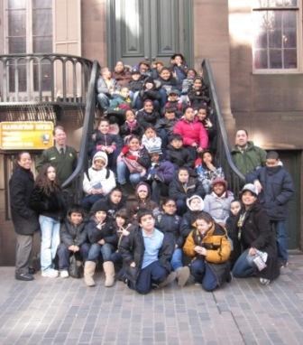 Students, teachers, and rangers gather on the steps of Theodore Roosevelt Birhplace NHS