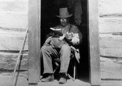 T.R. reading a book, with his dog, Skip. T.R. reading a book, with his dog, Skip.