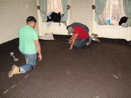 Laying down new carpet in the master bedroom.