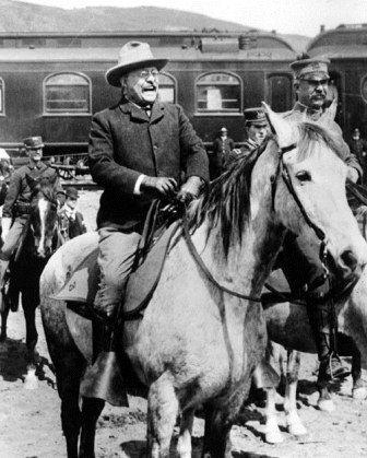 Theodore Roosevelt riding a horse.