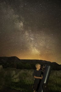 A young visitor looking through a telescope