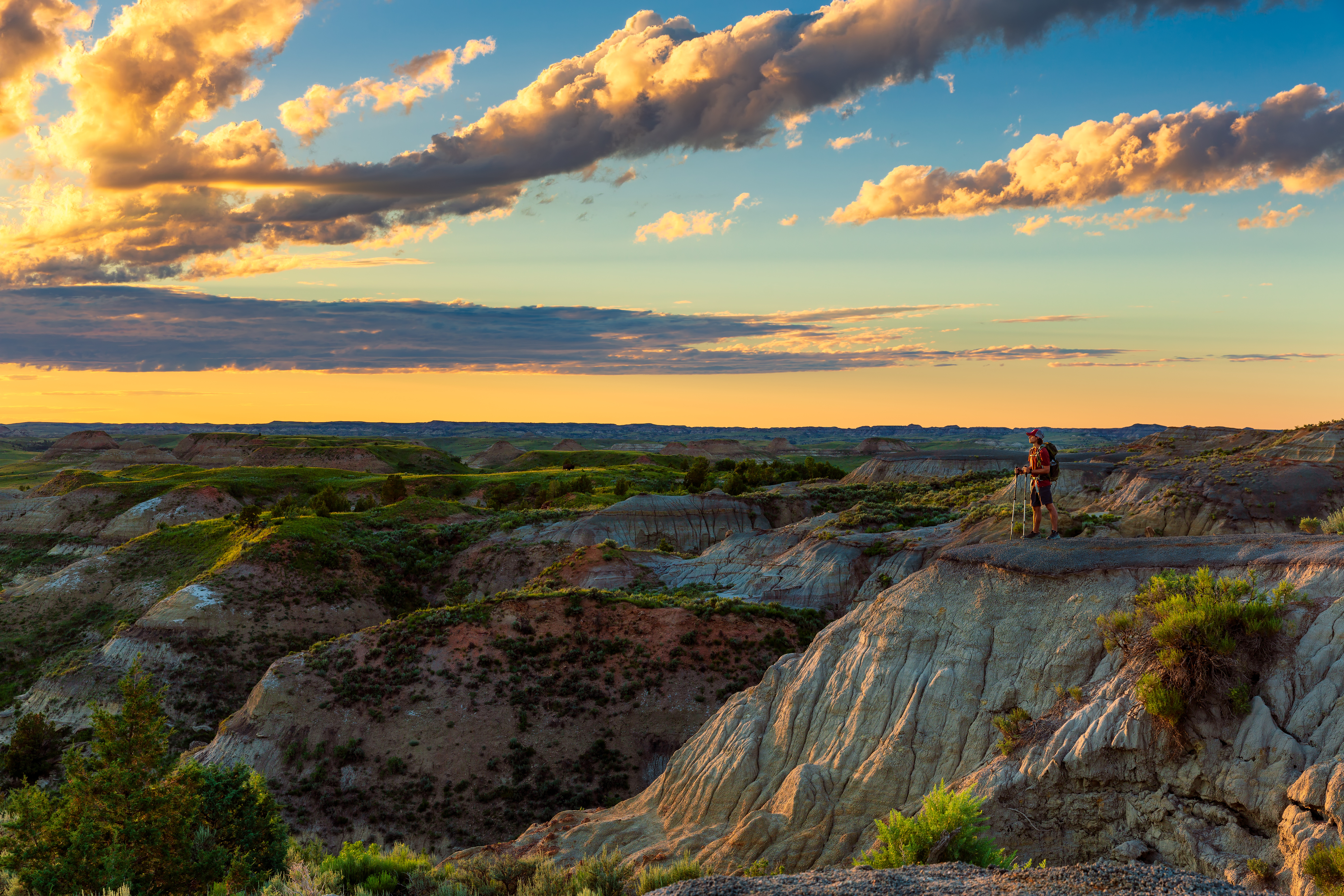 Wilderness A hiker stands on the edge of a butte looking over the North Dakota badlands.