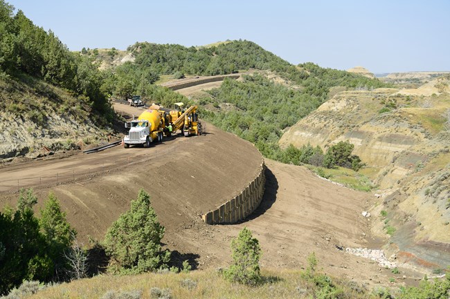 A dirt road with construction equipment on it.