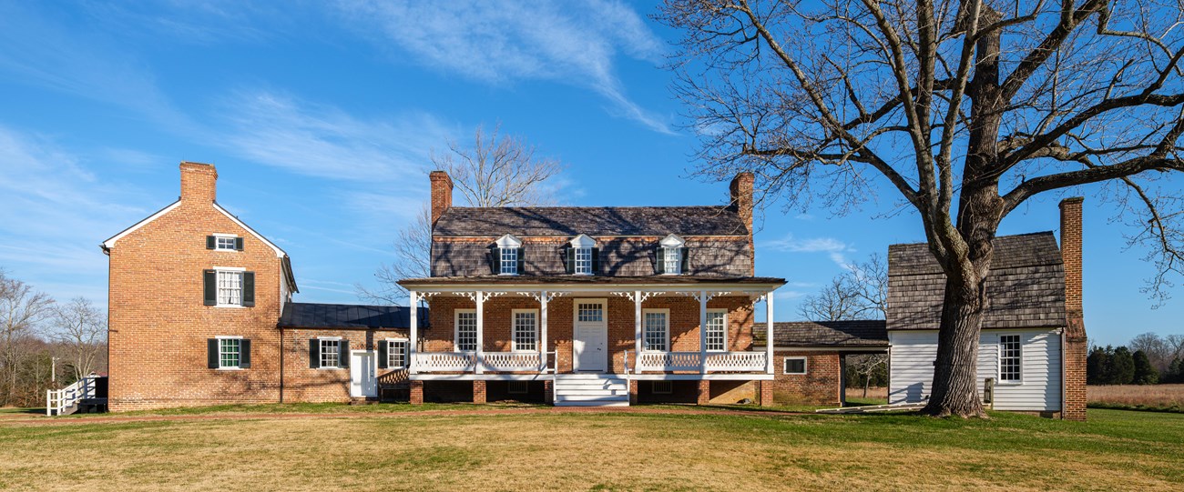 a large mansion sitting in an open field with a bright blue sky