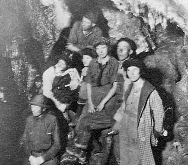 Early cave discoverers in a grainy black and white photo